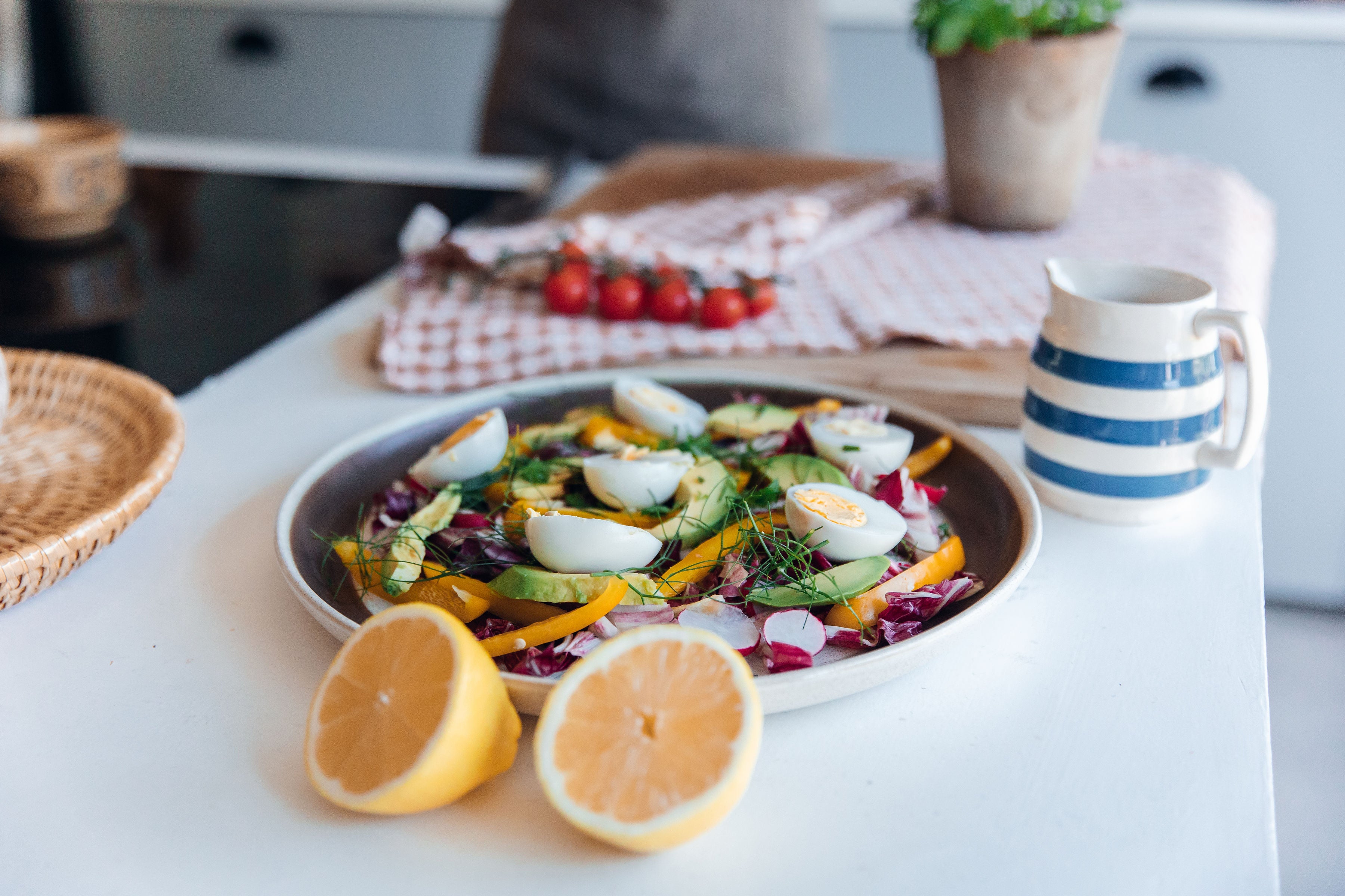 Colorful salad with lemon halves on a kitchen counter
