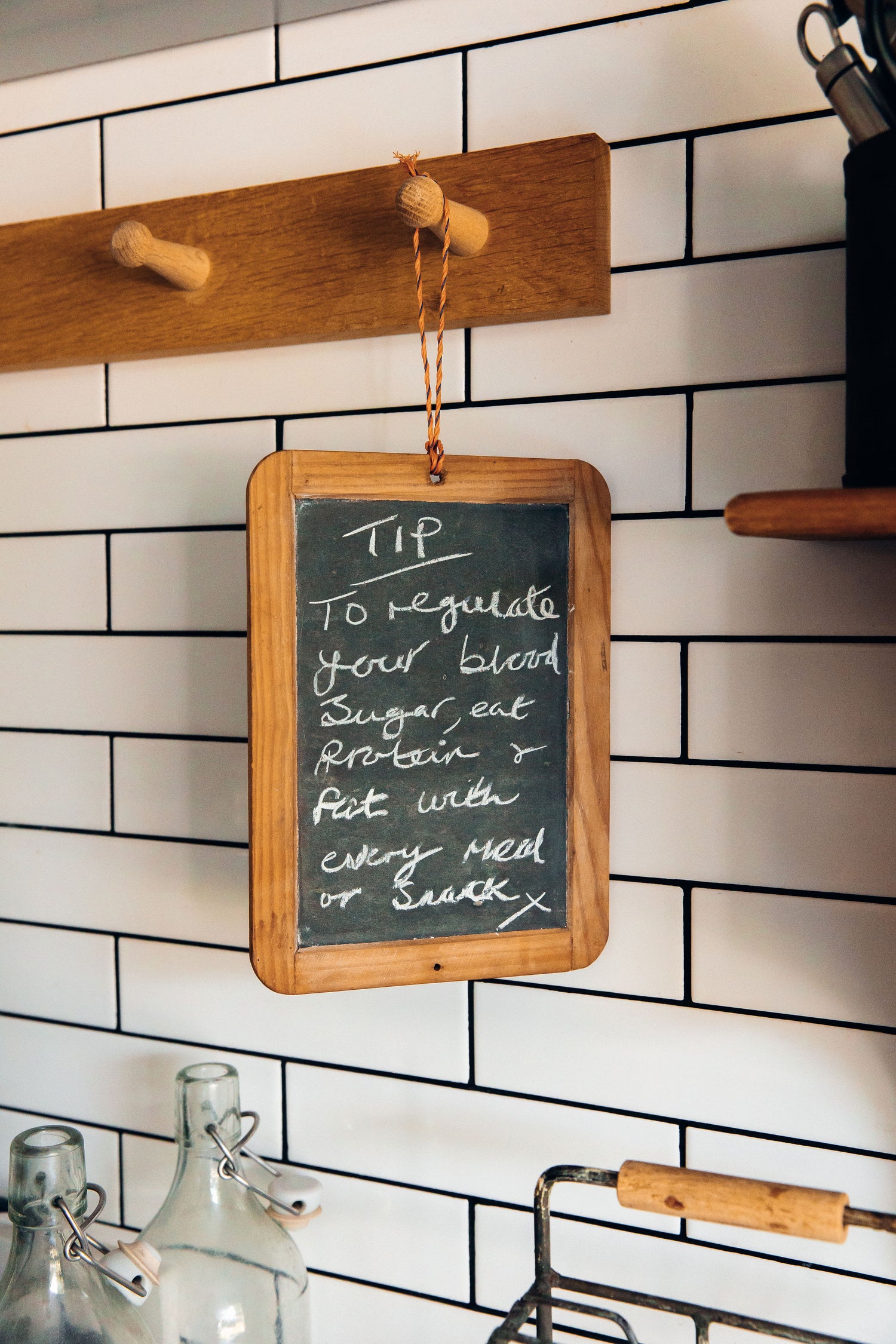 Wooden frame with a chalkboard on a tiled wall, displaying a health tip.